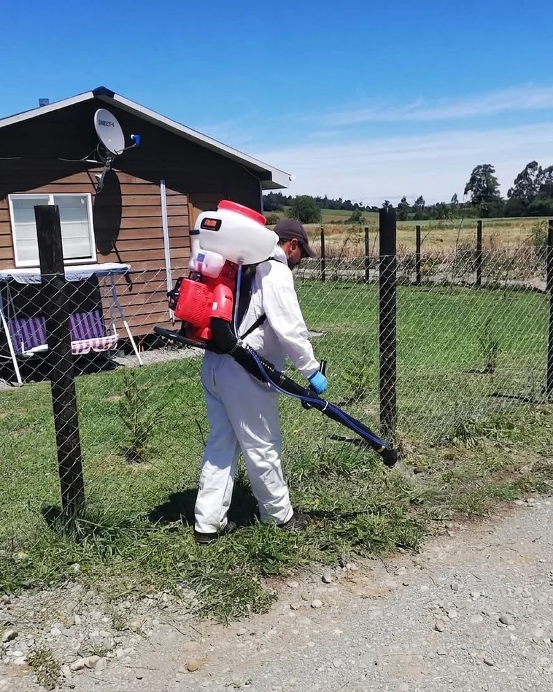 Técnico realizando una fumigación en un área exterior